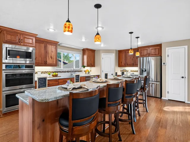 Kitchen featuring wood-finish flooring, recessed lighting, and a large central island with seating