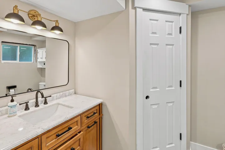 Vanity with an integrated rectangular sink, stone-finish countertop, and wood-finish cabinetry