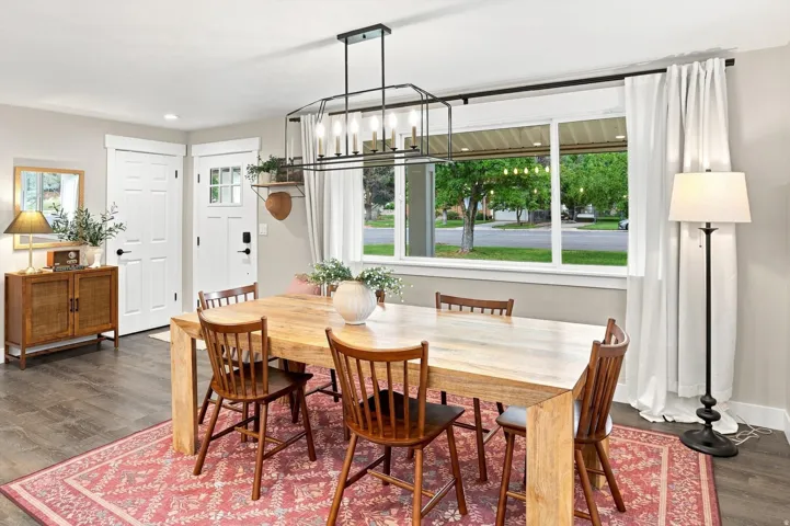 Wood-finish flooring, white trim, and a prominent window with a black rod