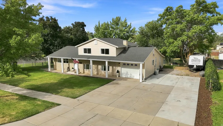 Two-story residence featuring a covered front porch, attached two-car garage, and a concrete driveway