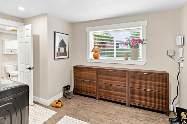 Wood-finish flooring with a neutral wall color, white trim, and a white interior door with black hardware