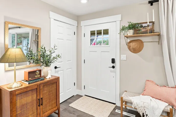 Entryway featuring a white paneled door with windowpanes, dark hardware, and wood-finish flooring