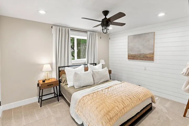 Shaker-style wood paneling, recessed lighting, ceiling fan with integrated light fixture, carpet flooring, and a large window