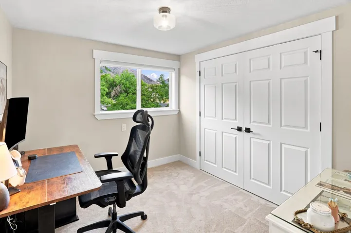 Neutral-toned carpeting, white trim work, and a window with exterior landscape