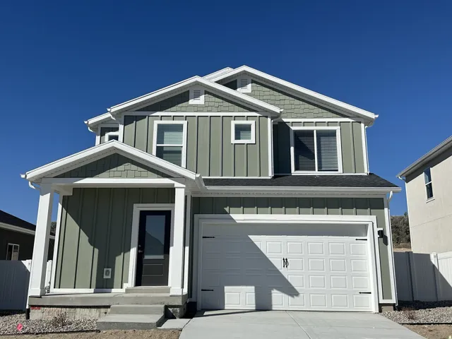 Two-story residence featuring shingle accents, board and batten siding, an attached two-car garage, and a covered entry porch