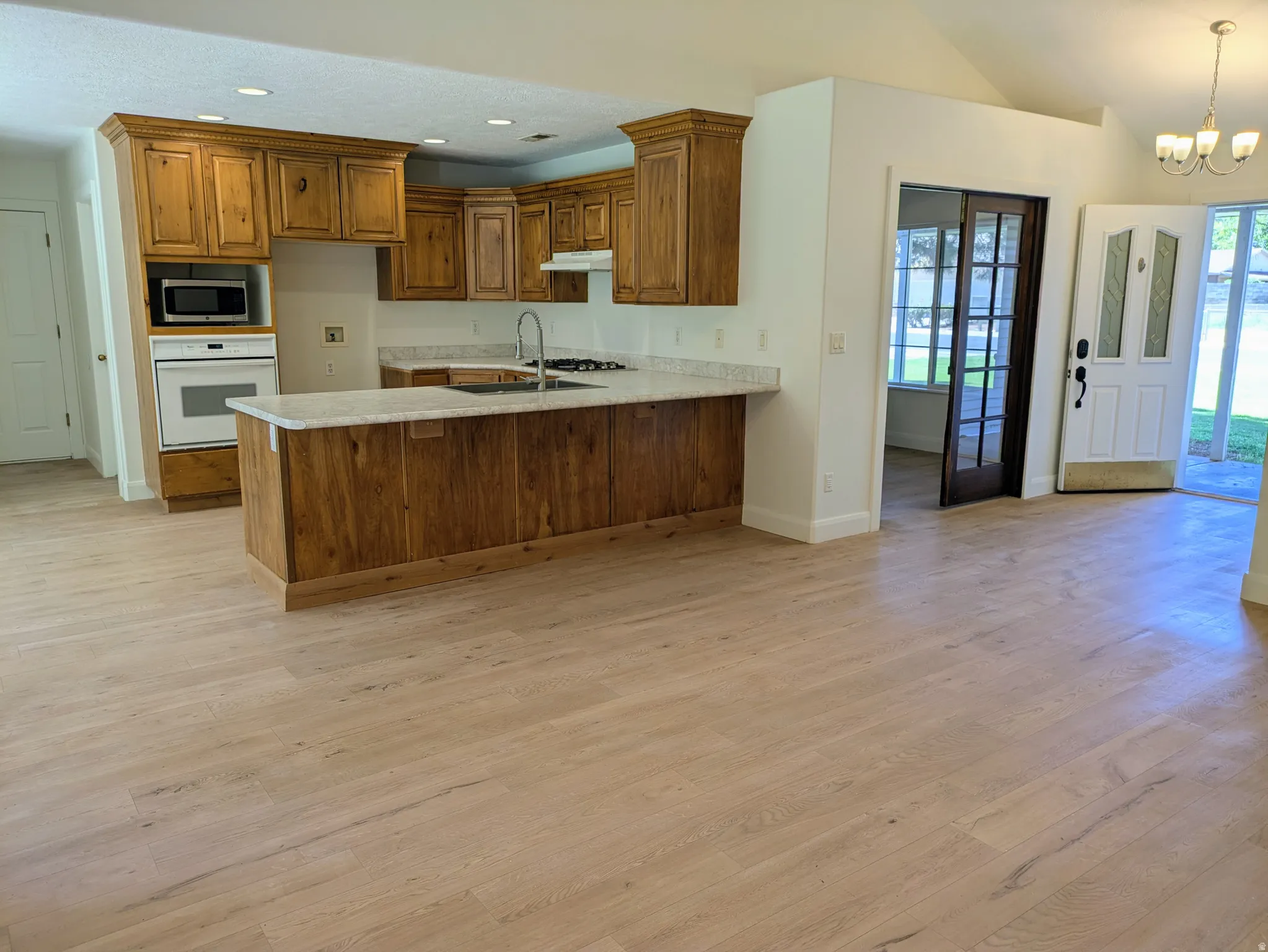 Kitchen featuring natural wood cabinetry, light-toned countertops, and built-in appliances