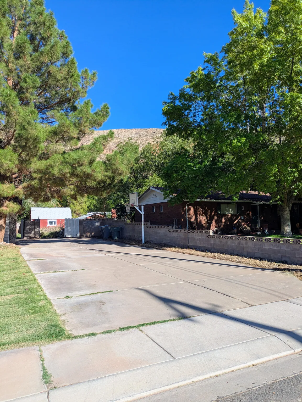Paved concrete pad with adjacent sidewalk and grass border