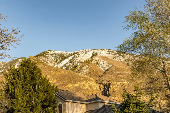 Property featuring a tile roof and arched window, with a mountainous backdrop