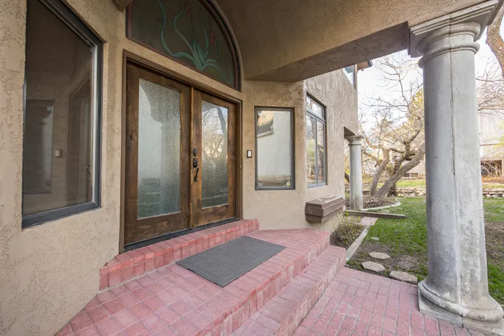 Double-door entryway with frosted glass inserts and an arched transom window featuring decorative glasswork
