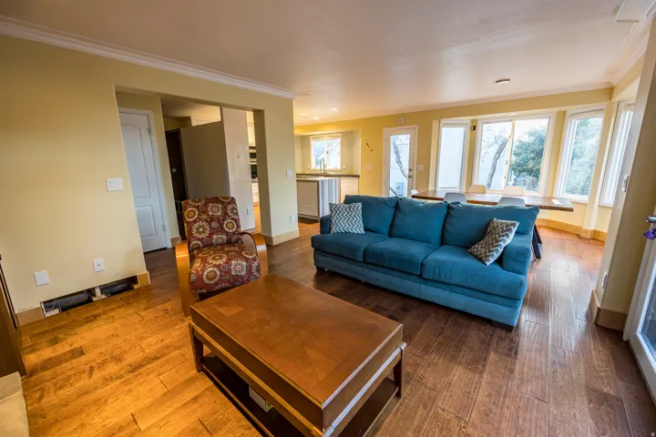 Wood-finish flooring throughout, crown molding, and a bay window