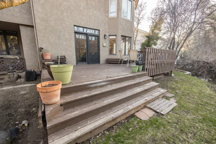 Spacious outdoor deck with steps, privacy screen, and direct access to interior via sliding glass doors