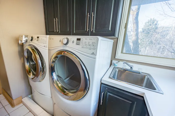 Built-in upper cabinetry, utility sink, and window