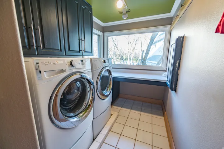 White tile flooring and a built-in countertop with storage cabinets