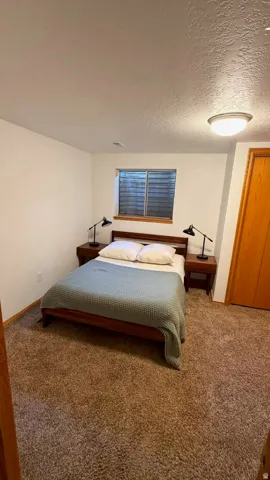 Carpeted room featuring white walls, a single window, and a flush-mount ceiling light