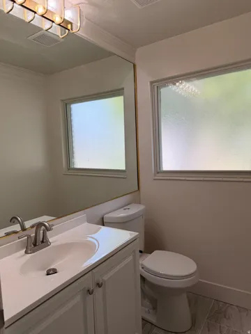 White vanity with a single basin sink and brushed nickel faucet