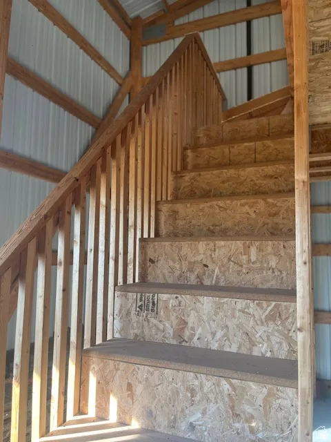 Wood-frame staircase with oriented strand board risers and treads, featuring a wood balustrade and handrail