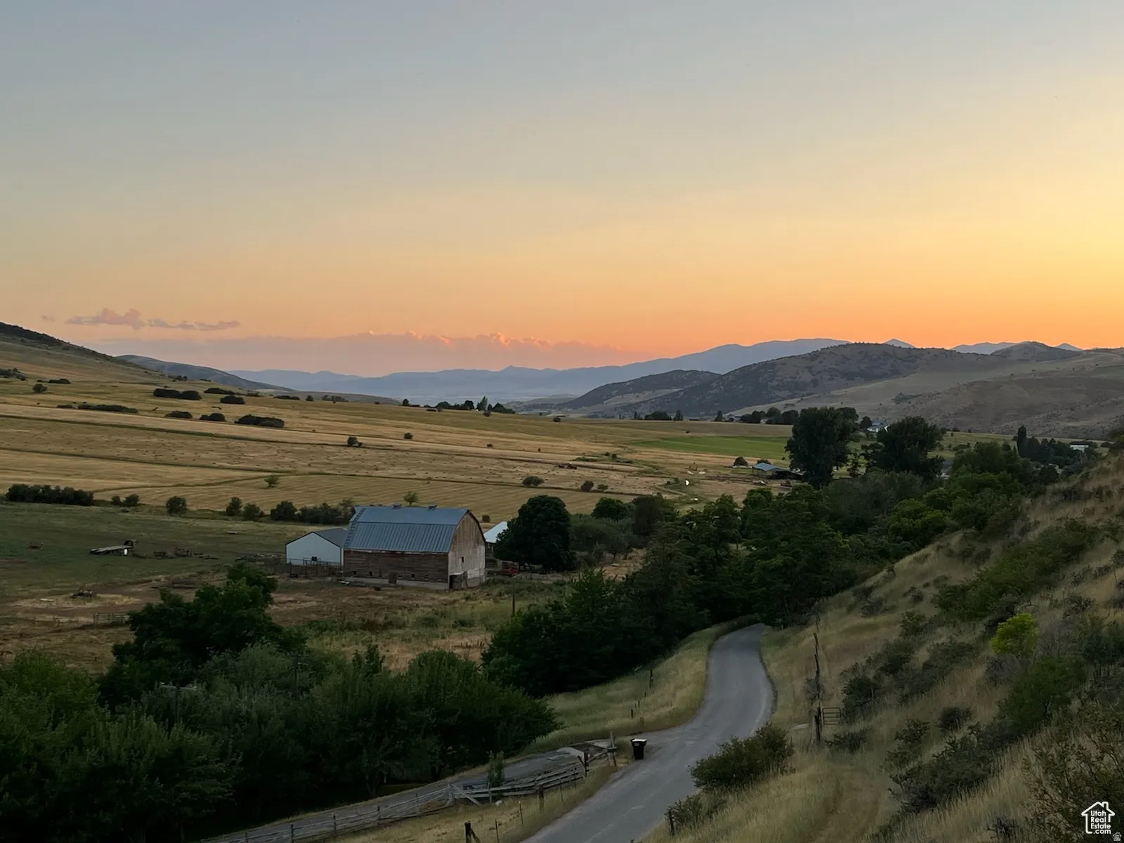 Expansive rural landscape featuring rolling hills and distant mountains