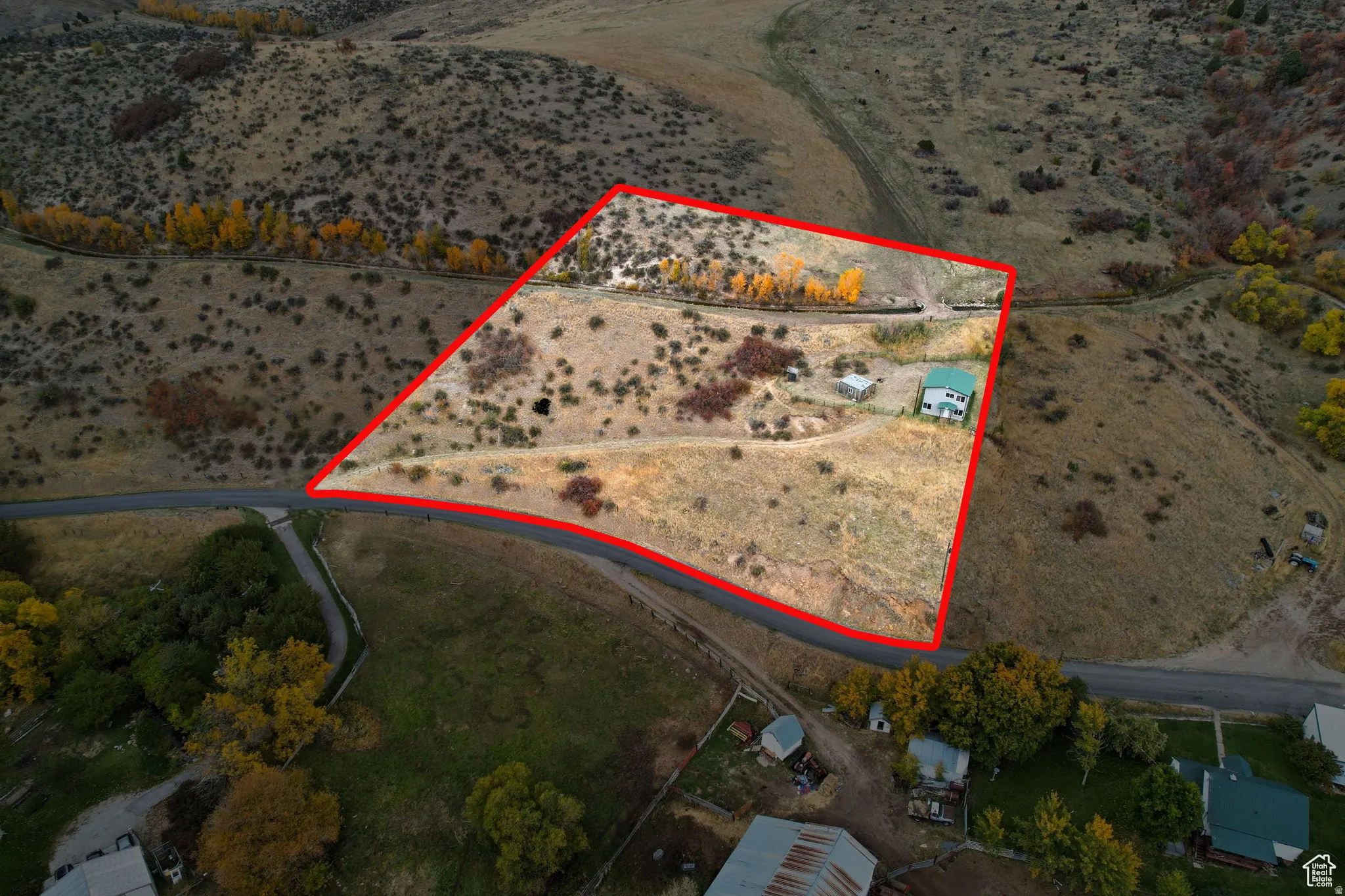 Expansive parcel featuring a two-story residence with a green roof, a secondary outbuilding, and mature trees
