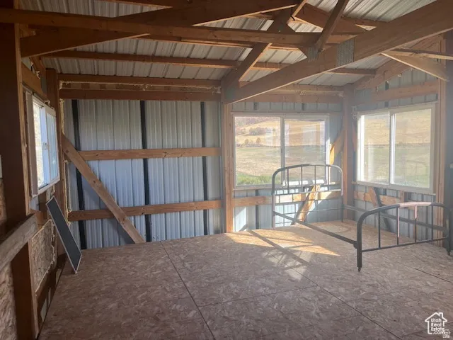 Exposed wood beam construction, corrugated metal wall panels, and multiple windows