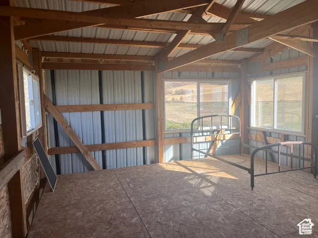 Exposed wood beam construction, corrugated metal wall panels, and multiple windows