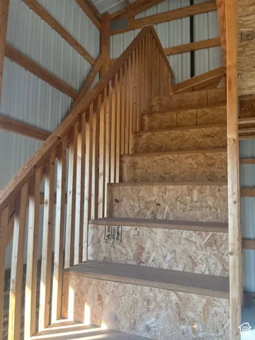 Wood-frame staircase with oriented strand board risers and treads, featuring a wood balustrade and handrail