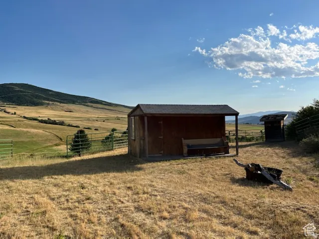 Wooden outbuilding with a covered porch and fenced perimeter