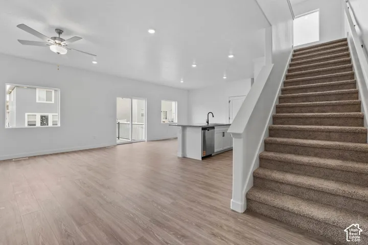 Open-concept living area featuring wood-finish flooring, recessed lighting, and a ceiling fan