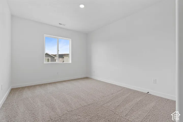 Recessed ceiling lighting, neutral carpeting, white walls, and a white trim