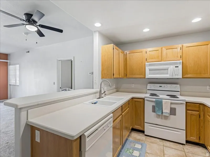 Kitchen featuring wood cabinetry, white countertops, built-in microwave, and electric range