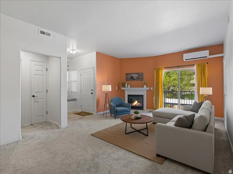 Living area with a built-in fireplace, sliding glass door, and a mini-split system