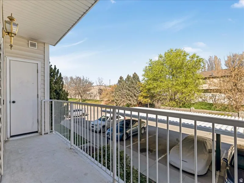 Private balcony with a white metal railing, an exterior storage closet, and an overhead light fixture