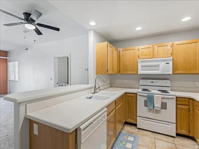 Kitchen featuring wood cabinetry, white countertops, built-in microwave, and electric range