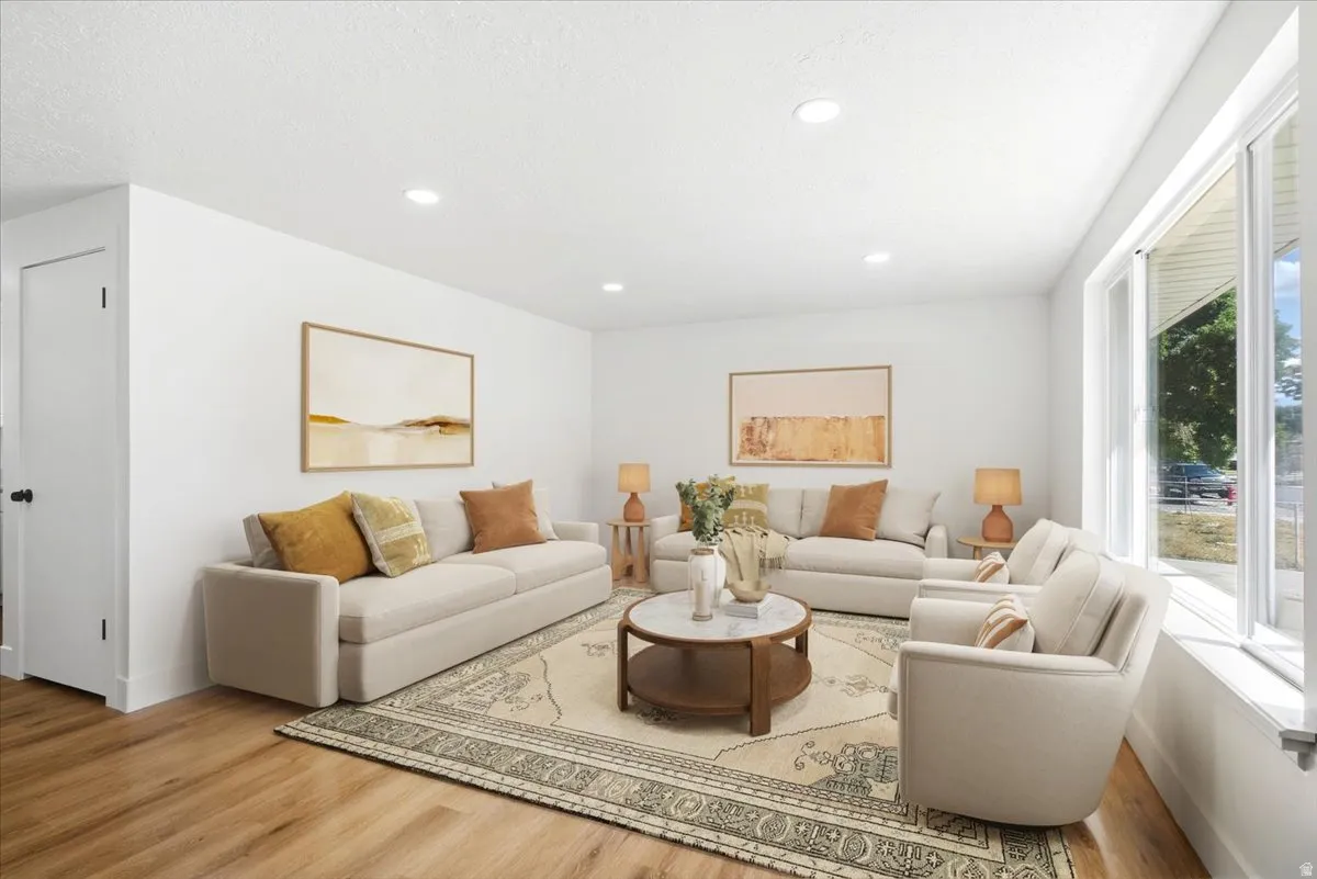 Recessed ceiling lighting, wood-finish flooring, white walls, and a large window with white trim