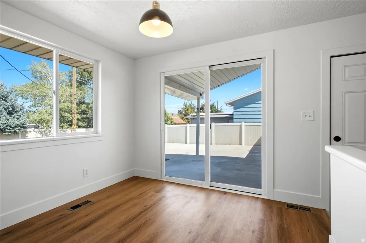 Wood-finish flooring, white walls, and a sliding glass door providing exterior access