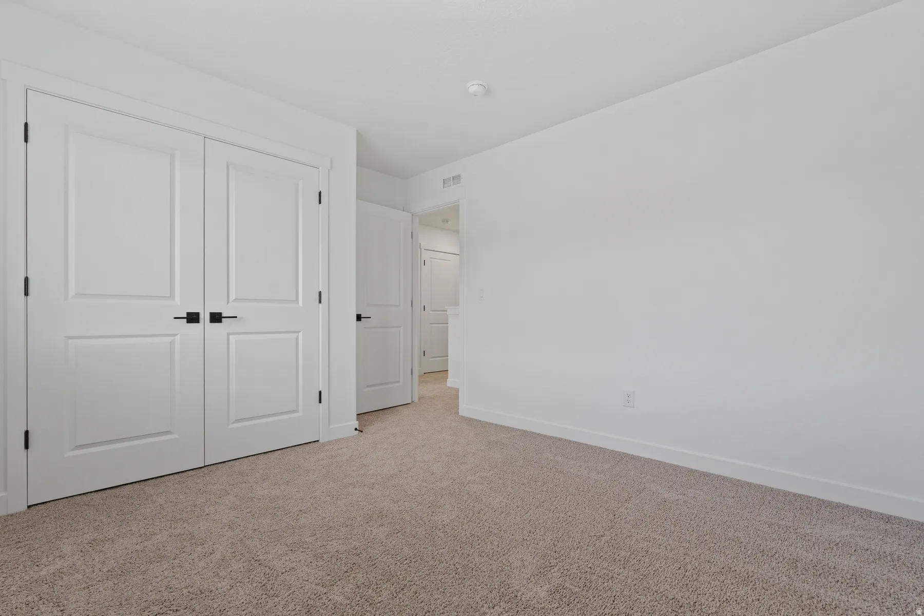 Neutral-toned carpeting, white walls, and white trim