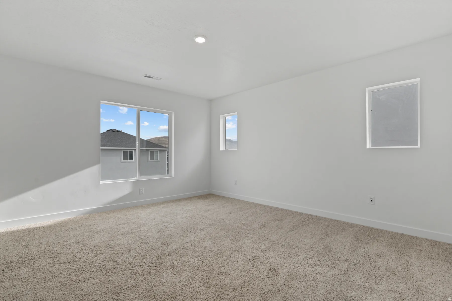 Neutral tone wall paint, recessed ceiling lighting, and carpeted flooring