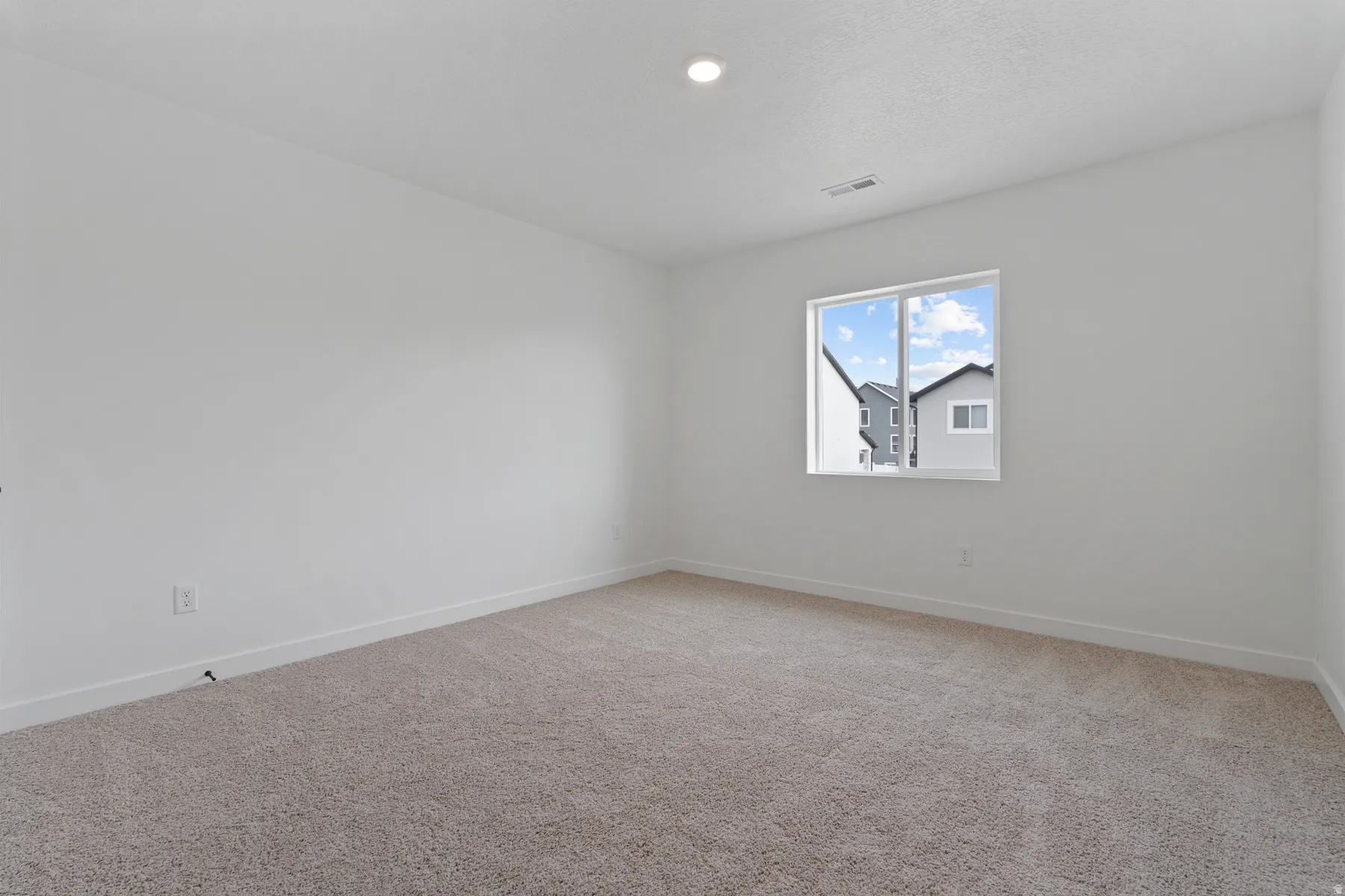 Wall-to-wall carpet flooring, recessed ceiling lighting, and a double-pane window