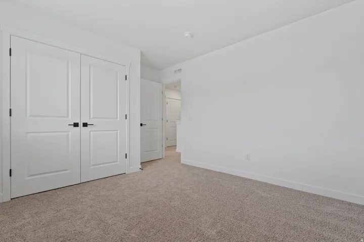 Neutral-toned carpeting, white walls, and white trim