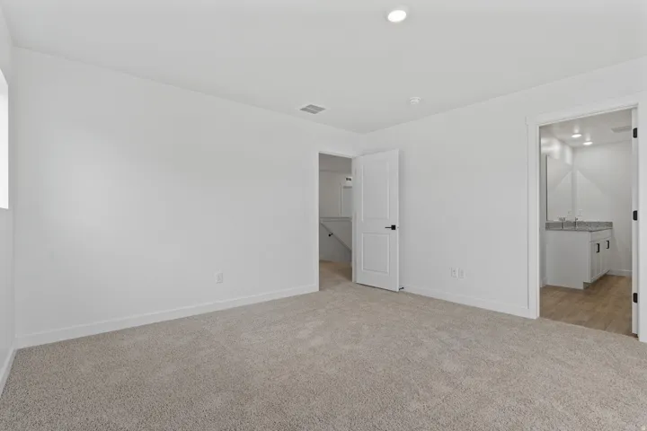 Neutral-toned carpeting and white walls with recessed lighting