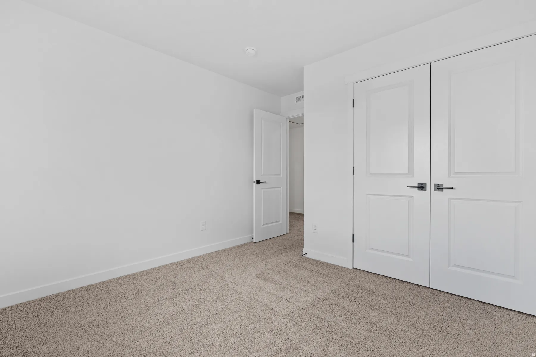 Neutral-toned carpet flooring and white walls