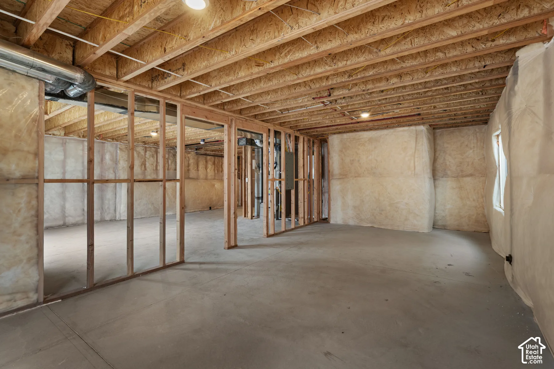 Unfinished basement featuring wood framing, concrete flooring, exposed ceiling joists, recessed lighting, and insulated walls