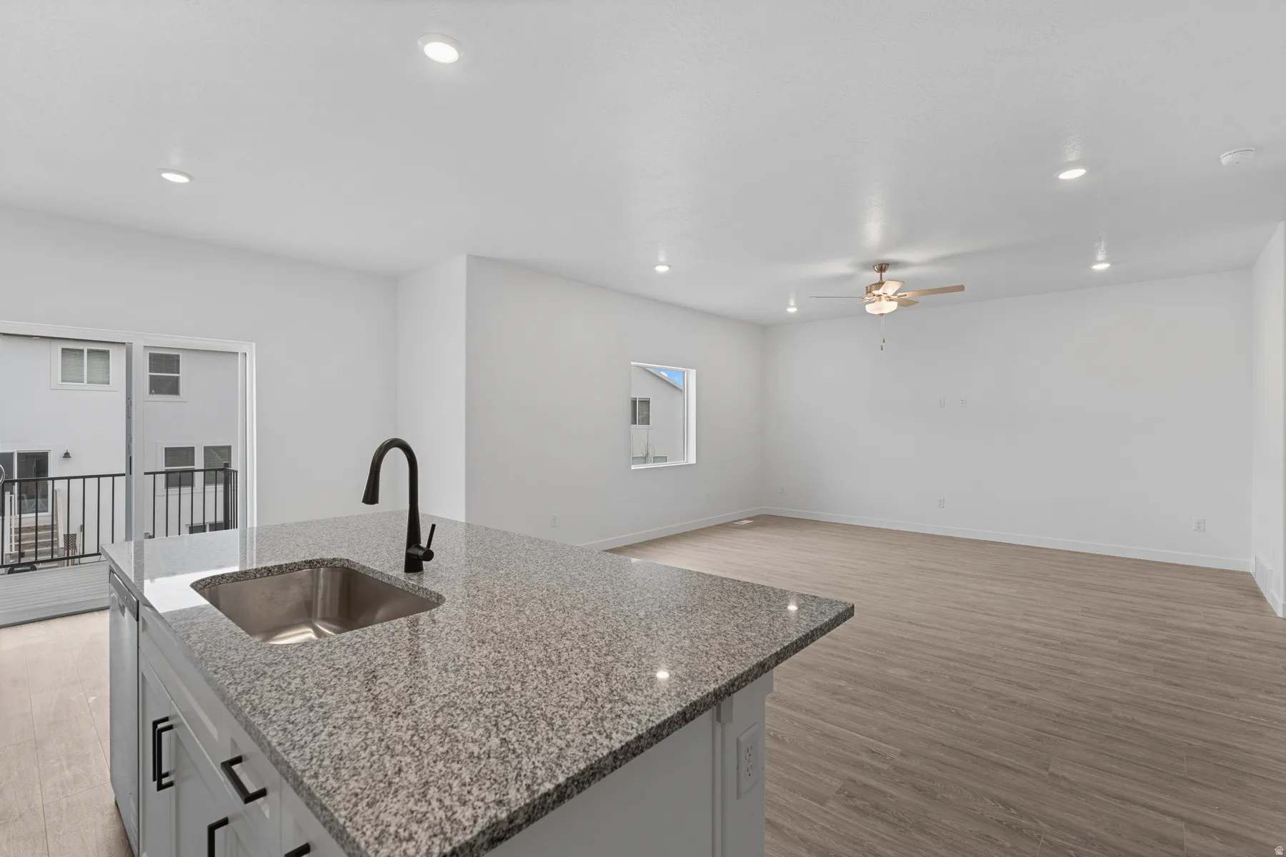 Kitchen island with a stainless steel sink, black faucet, and granite countertop
