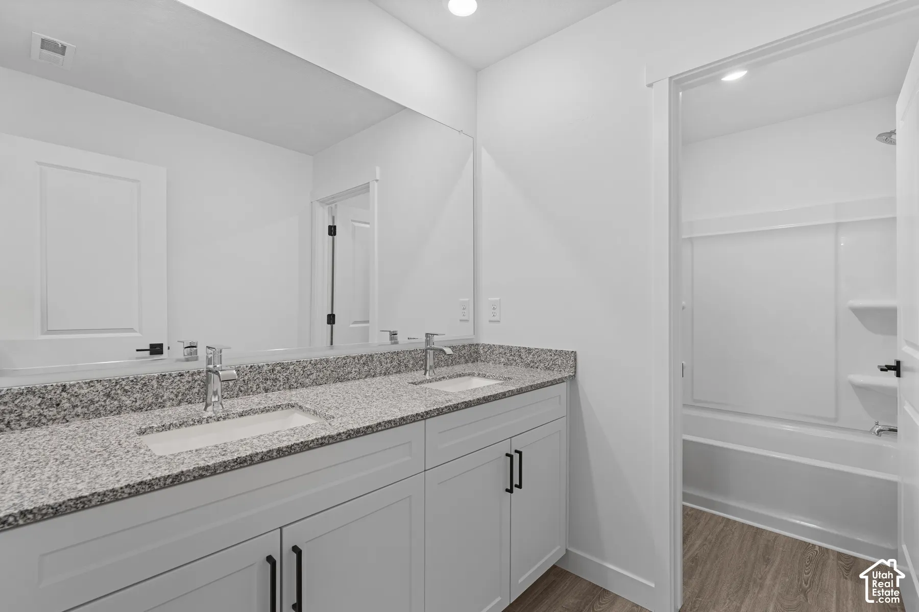 Dual vanity with undermount sinks and speckled stone countertops