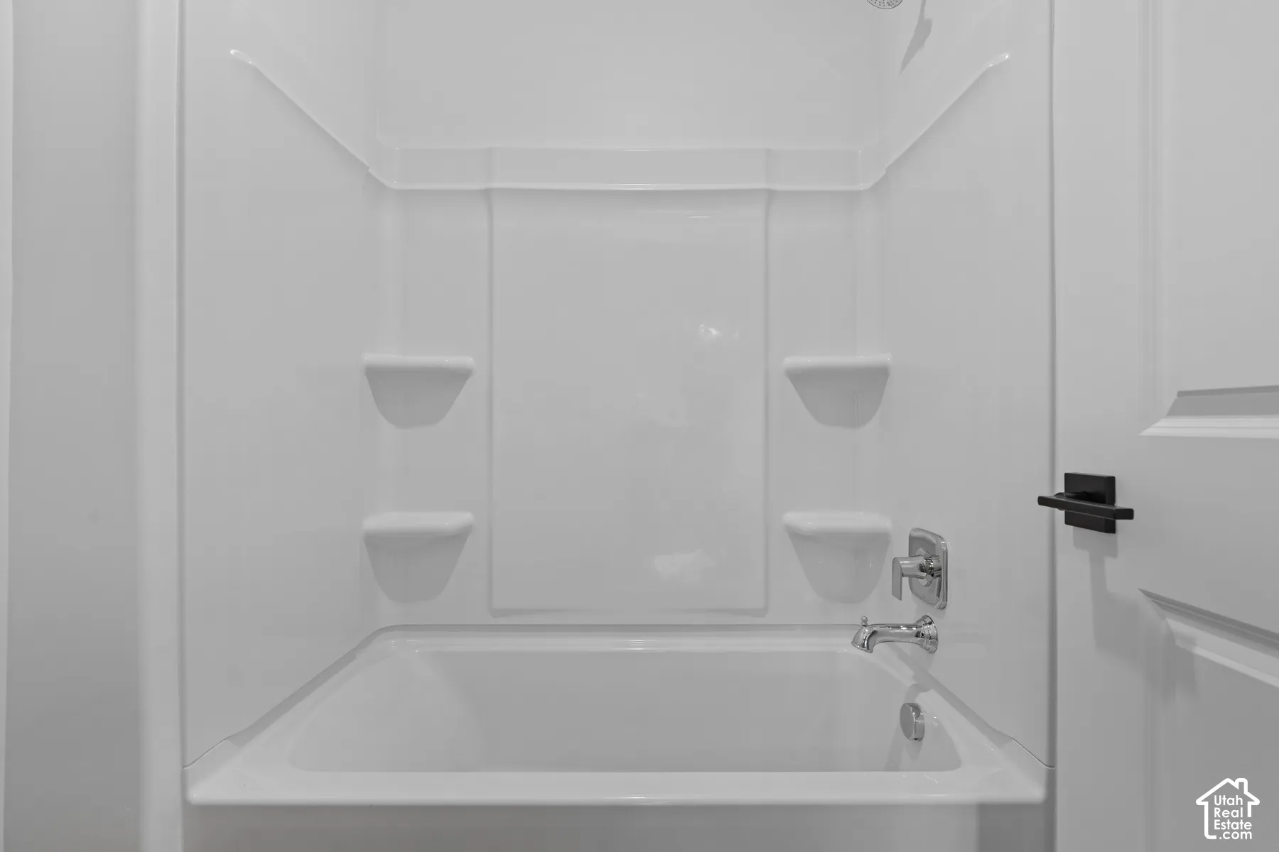 White tub and shower combination with built-in shelving