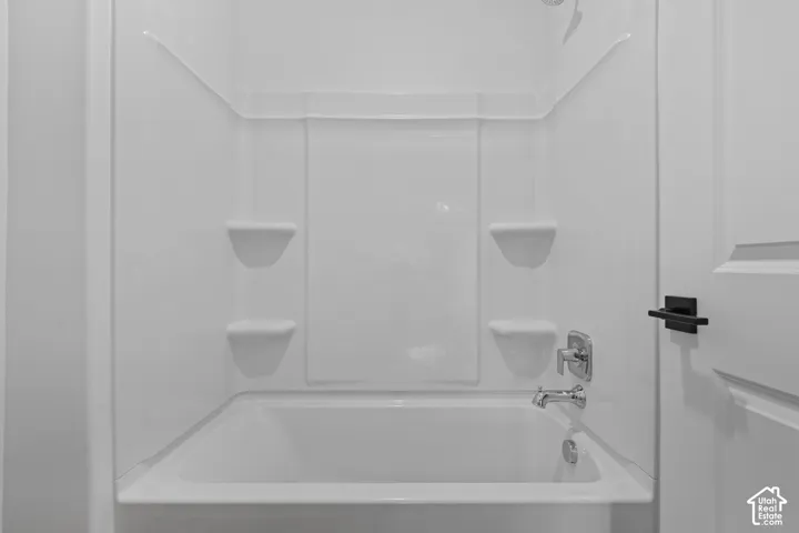 White tub and shower combination with built-in shelving