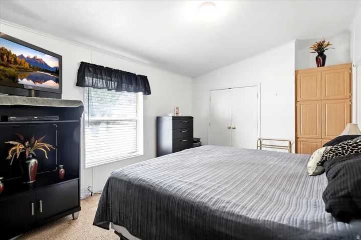 Built-in wood-finish cabinetry, white walls, and a window with horizontal blinds
