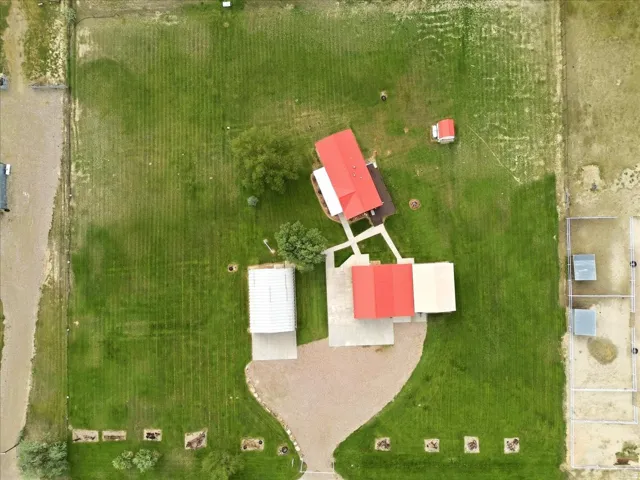 Expansive green acreage featuring multiple outbuildings, a detached garage, and distinct fenced areas