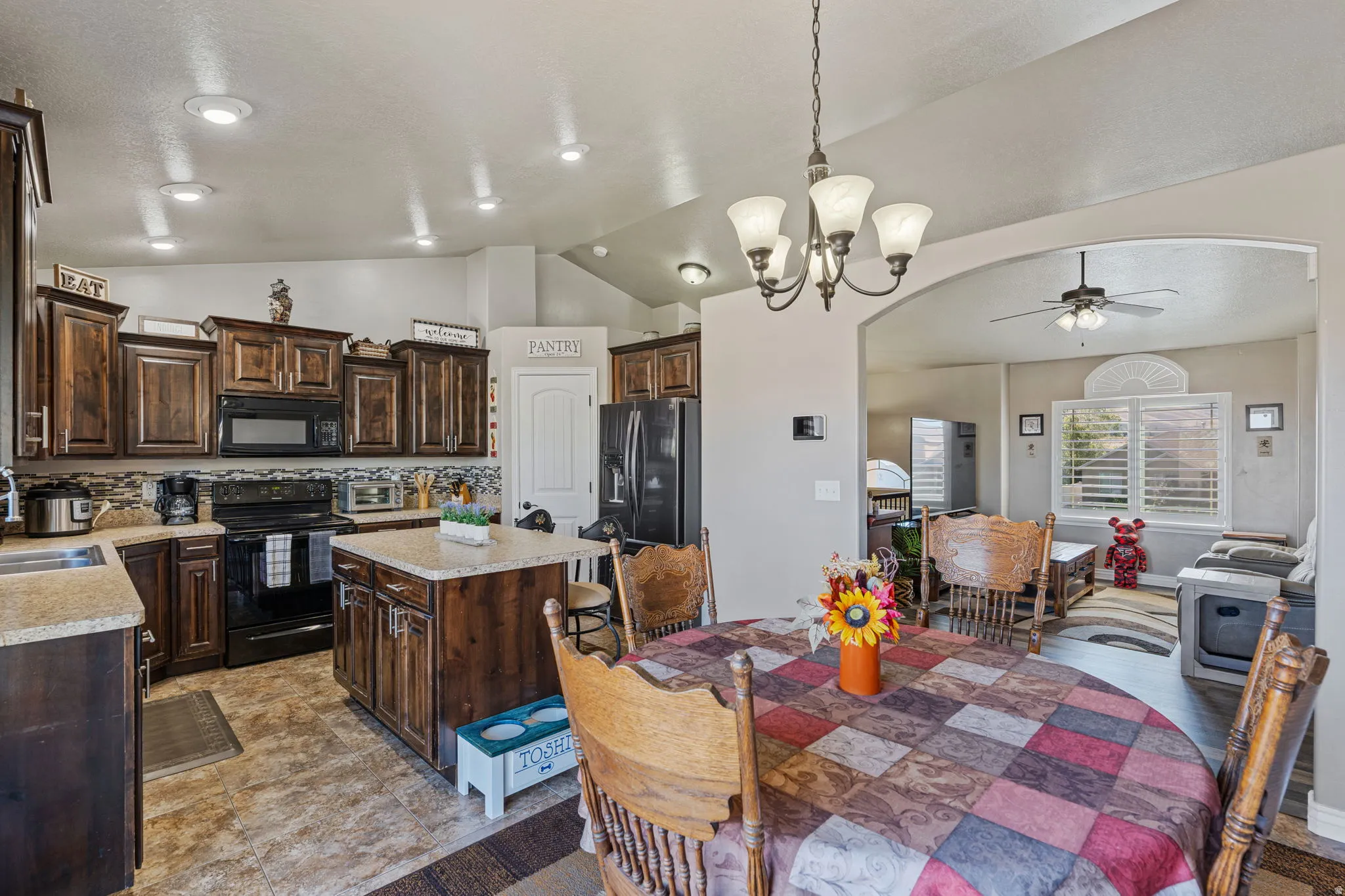 Kitchen featuring dark wood cabinetry, light countertops, integrated microwave, and a central island