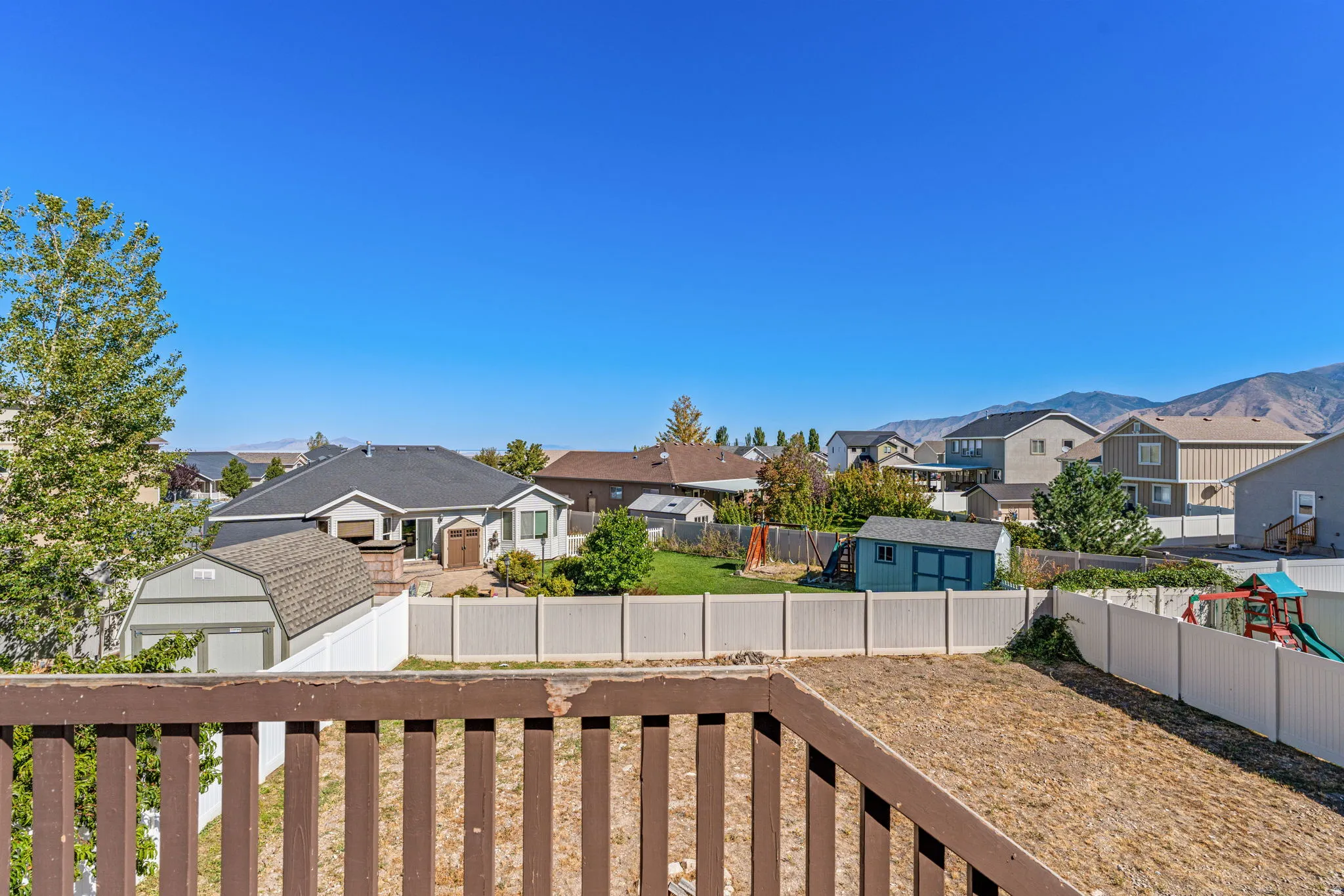 Private backyard space featuring a white privacy fence and a wooden deck