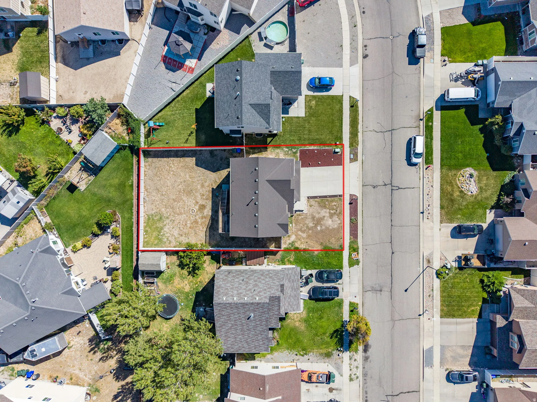 Property featuring a paved driveway, a detached shed, and a private yard space
